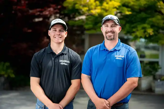 Two Colonial staff members in company polos posing together
