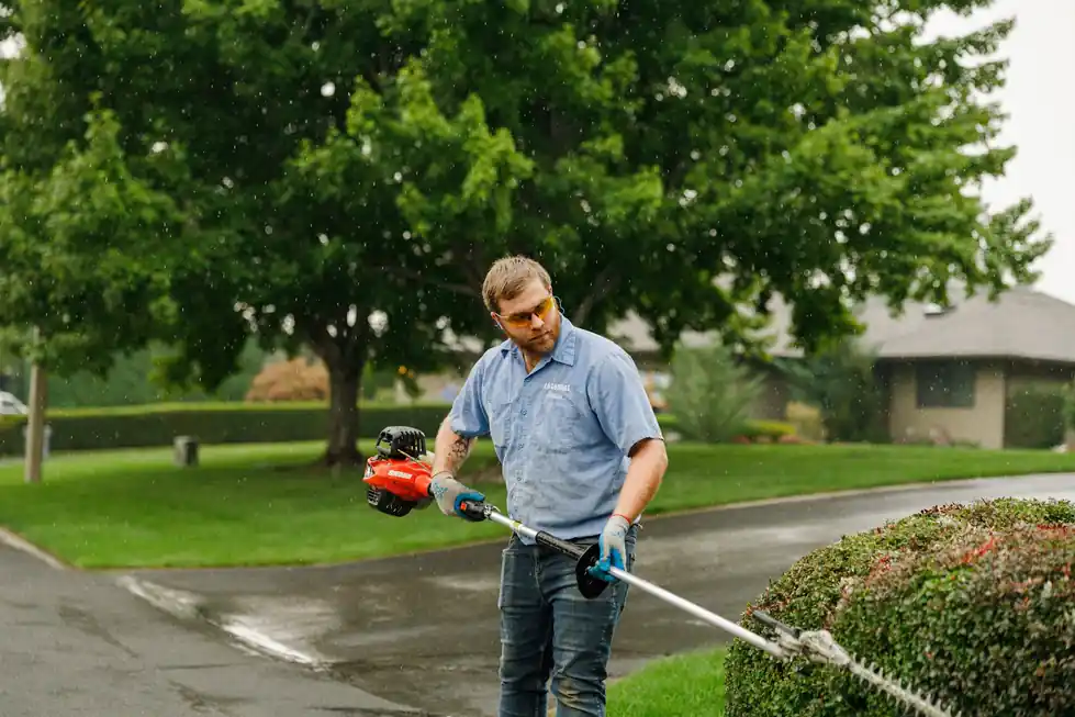 A Colonial maintenance technician edging a landscape bed