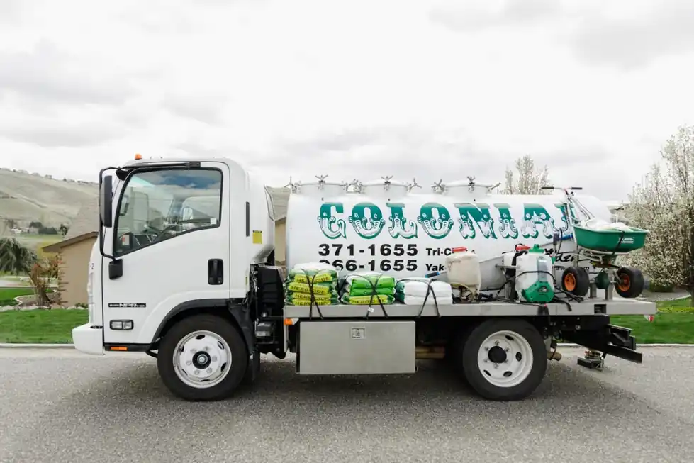 Colonial spray truck in profile, with the Tri-Cities and Yakima office numbers printed on the tank