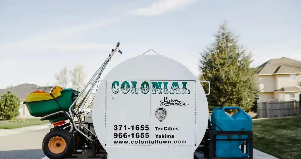 Rear of a Colonial spray truck tank lettered with both office phone numbers and the website